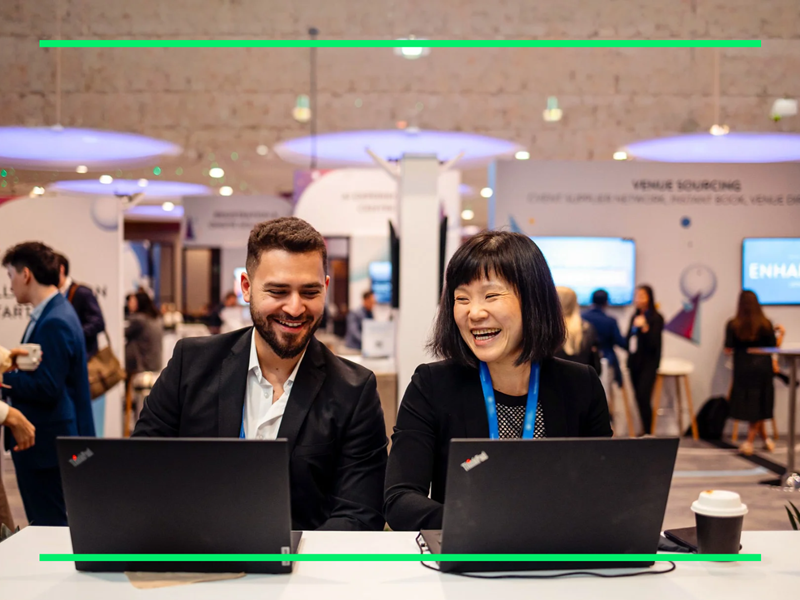 Two men and one women sitting facing latop.